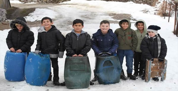 Hakkari'de çocuklar kızak ve plastik bidonlarla kayarak eğlendi